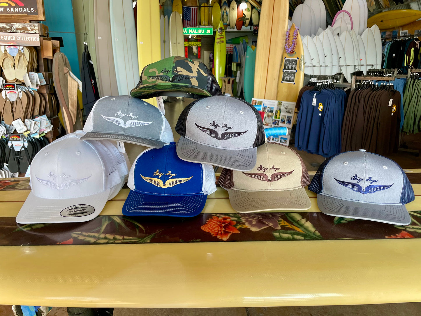 Collection of baseball caps on display in a store with various items in the background.