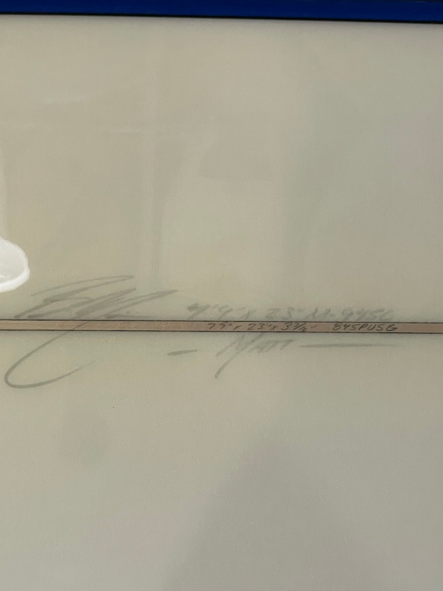 Close-up of a glass surface with writing and a blue border.