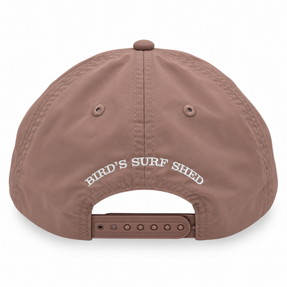 A dusty brown snapback cap shown from the back, featuring 'BIRD'S SURF SHED' embroidered in white across the back panels and an adjustable brown strap at the bottom.