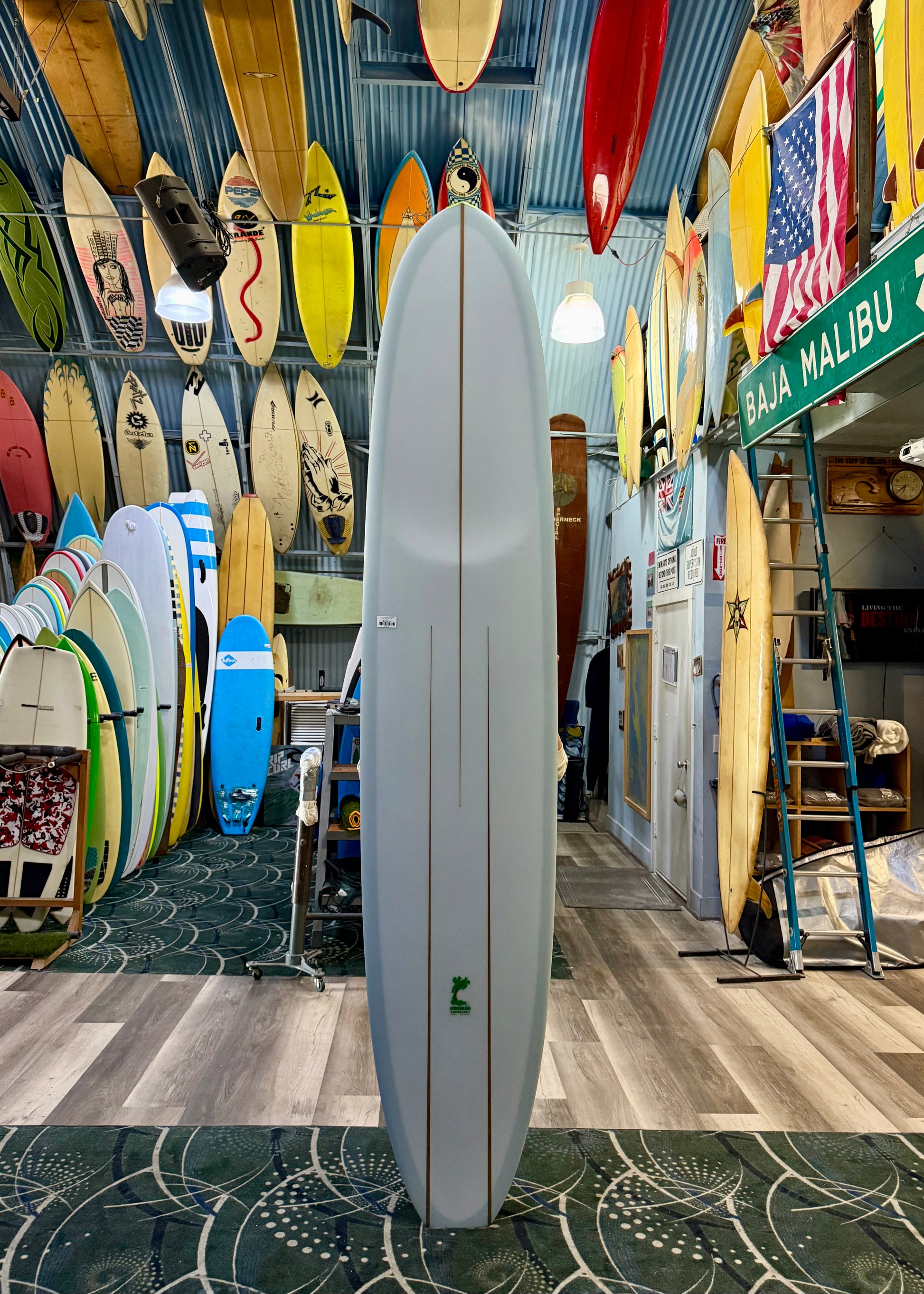 Surfboard shop with various surfboards on display, including a white surfboard in the foreground.