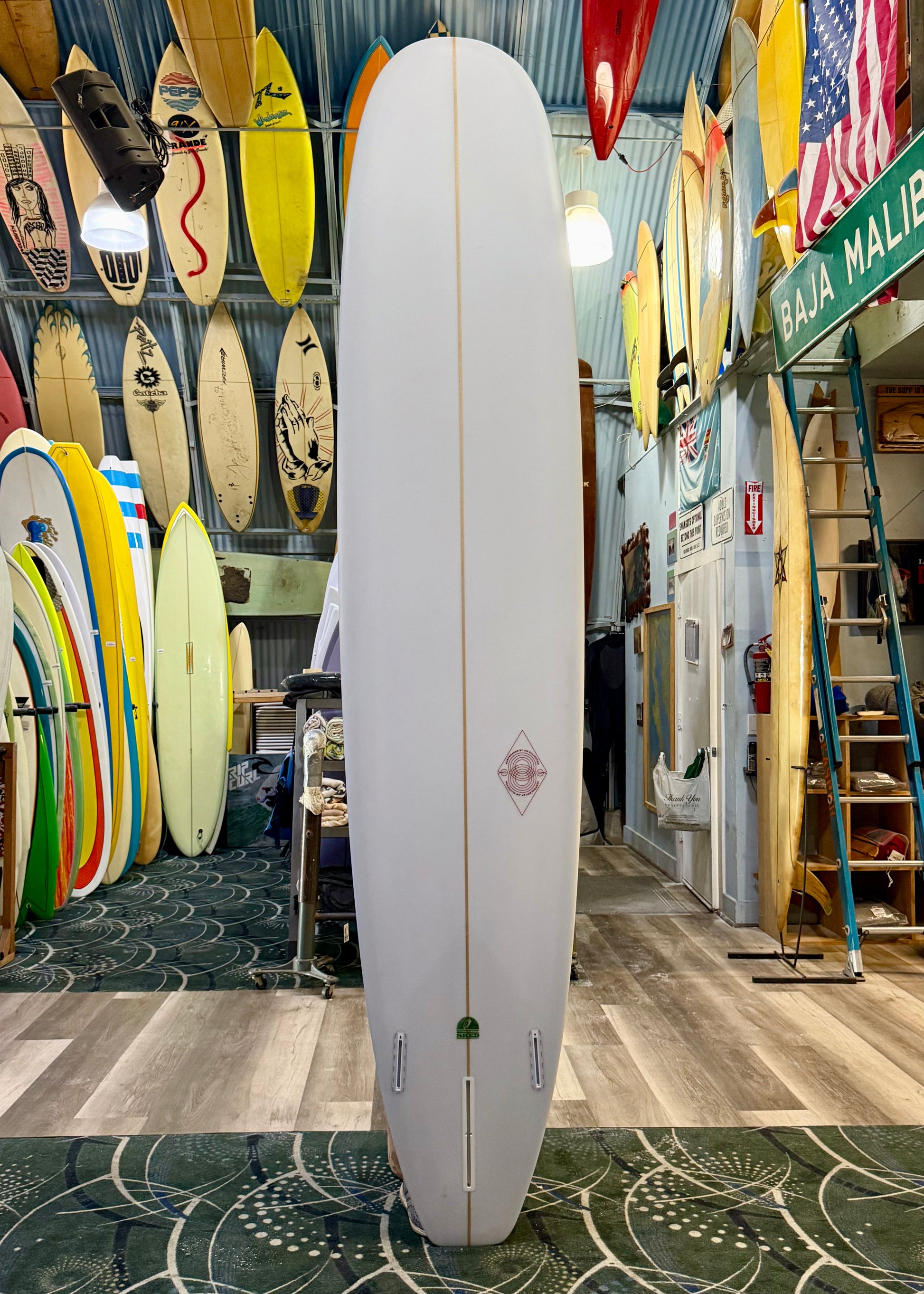 Surfboard in a surf shop with various surfboards and equipment in the background