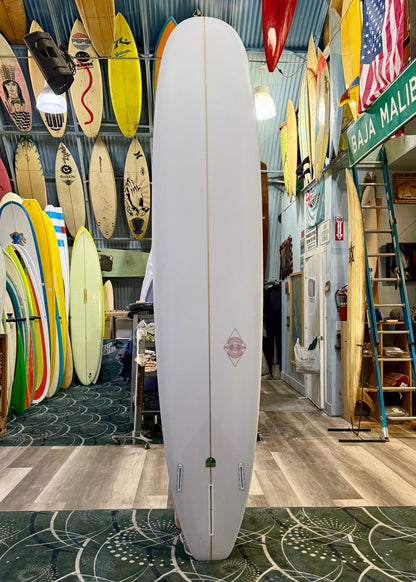 Surfboard in a surf shop with various surfboards and equipment in the background